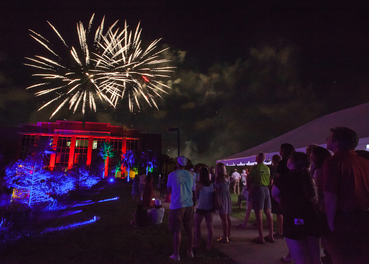 Crowd of people watching fireworks over the Olin Quad on campus