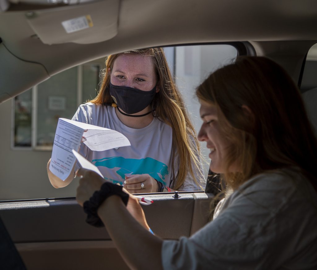 Student Elizabeth Christ fills out forms while in the car while volunteer Natalie Holliday waits for the form.
