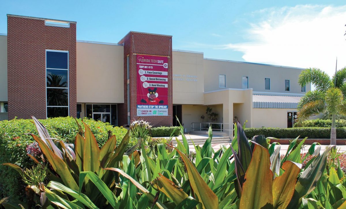 Denius Student Center with a banner showing Panther Pete wearing a face mask and reading "Florida Tech Safe; Easy as 123: 1. Face Coverings 2. Social Distancing 3. Hand Washing; Panthers stop the spread; Check in daily with #CampusClear"