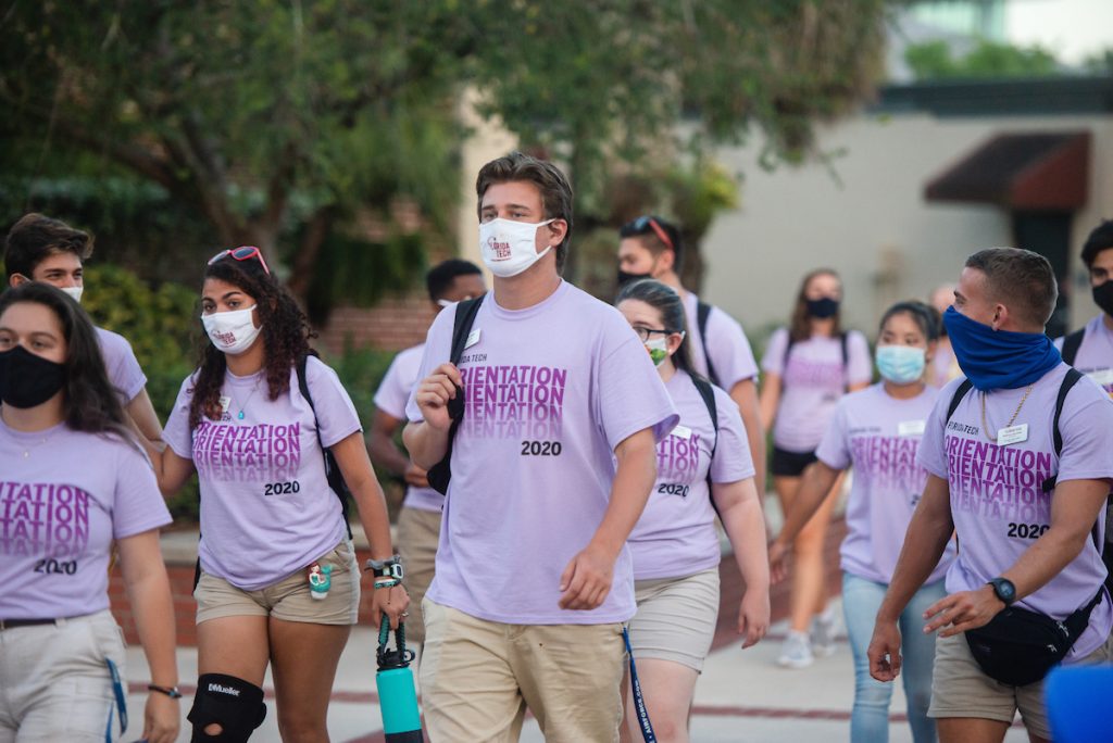 Group of students wearing "Orientation 2020" t-shirts and face masks on campus