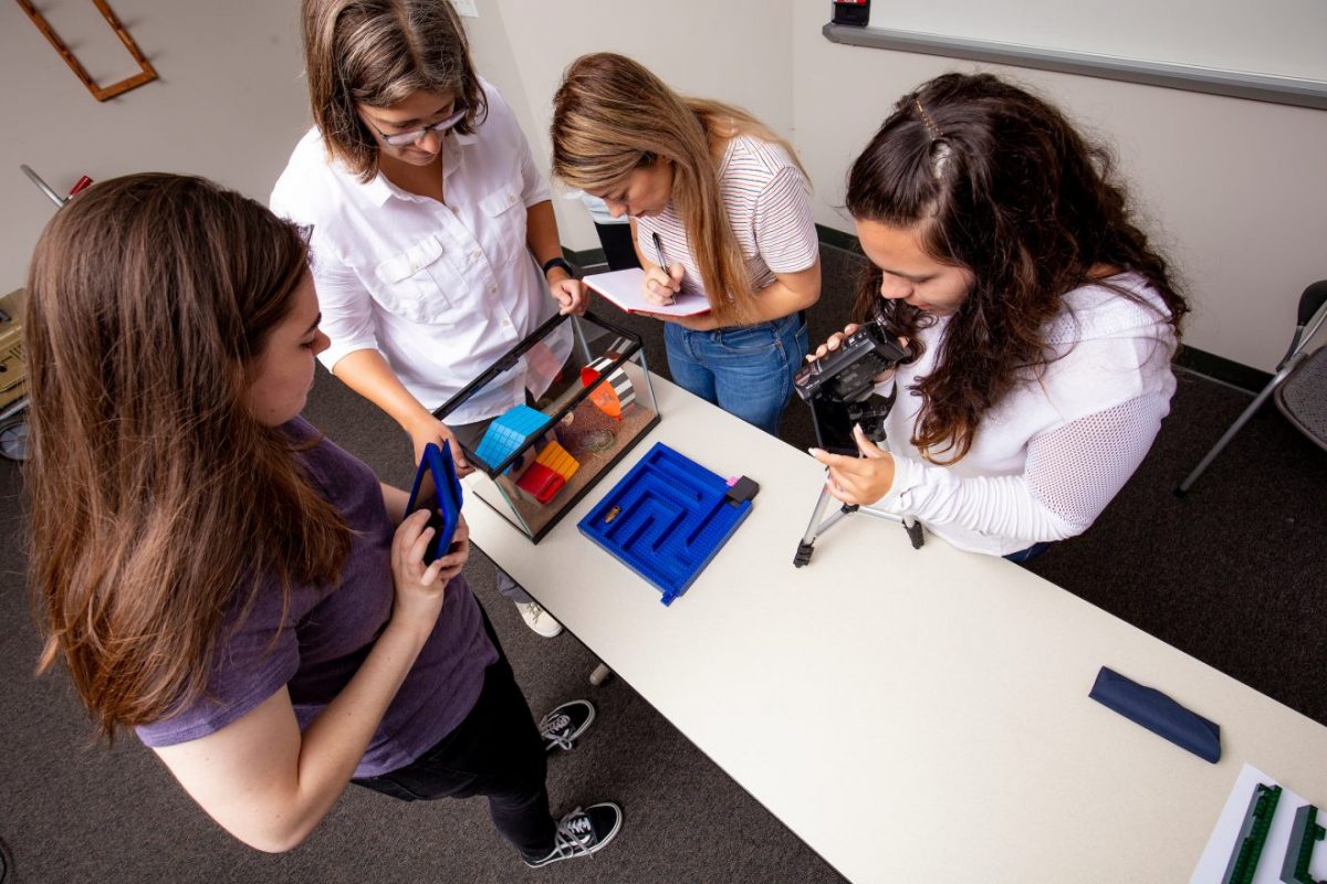 Teacher and students analyzing cockroach.