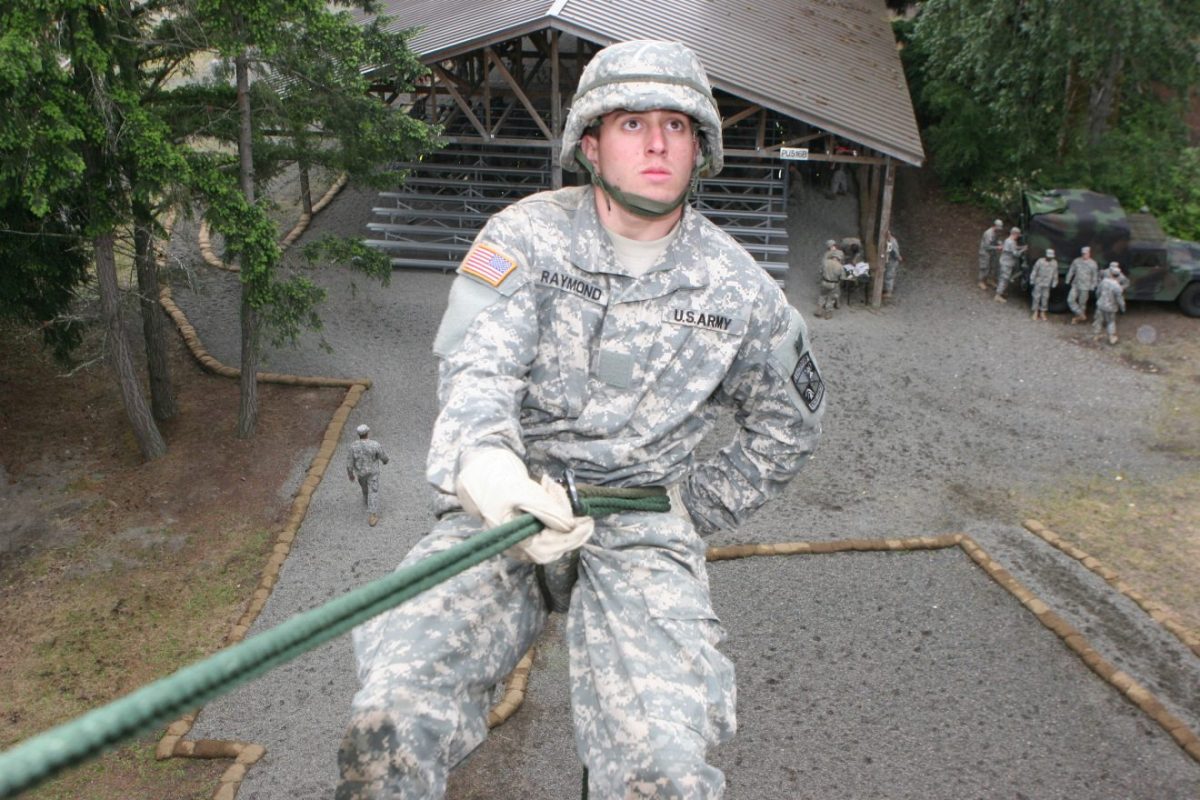 an ROTC student in camo repelling down a wall