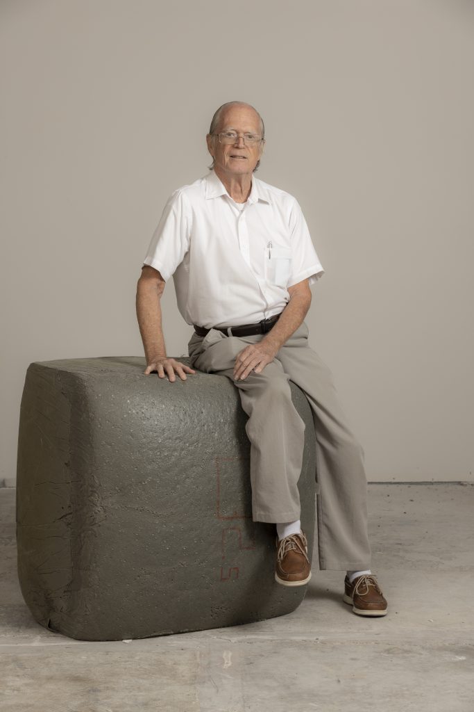 Florida Tech professor Gordon Nelson sits on a block of the flame-resistant foam he has helped develop over this career.