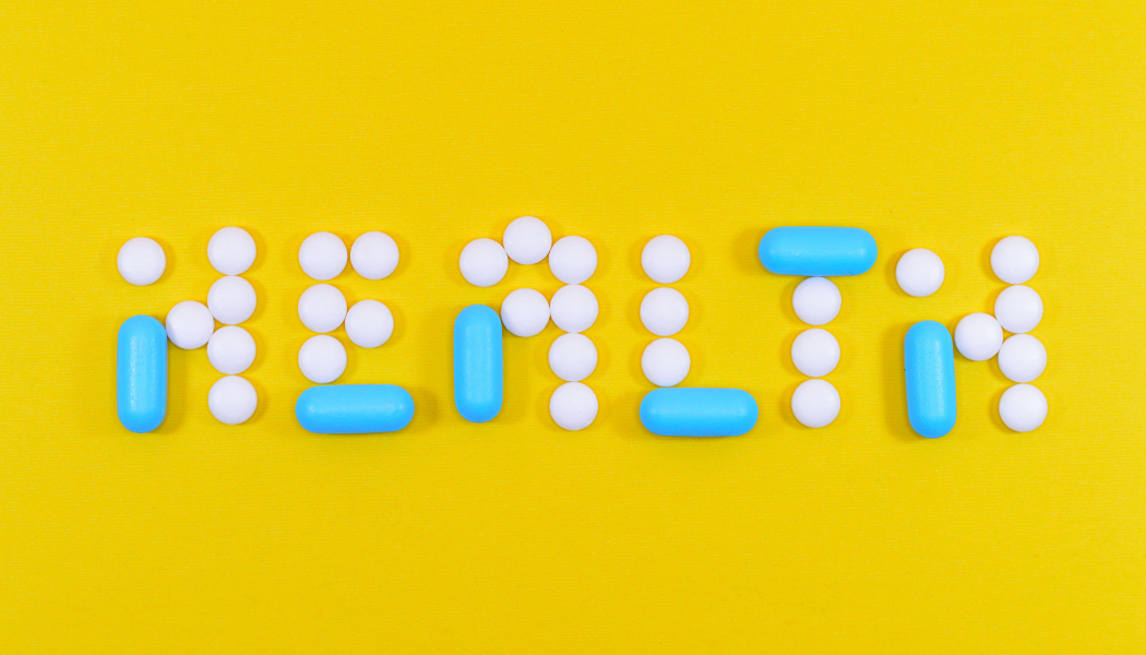 Pills on a yellow background spelling out the word "Health"