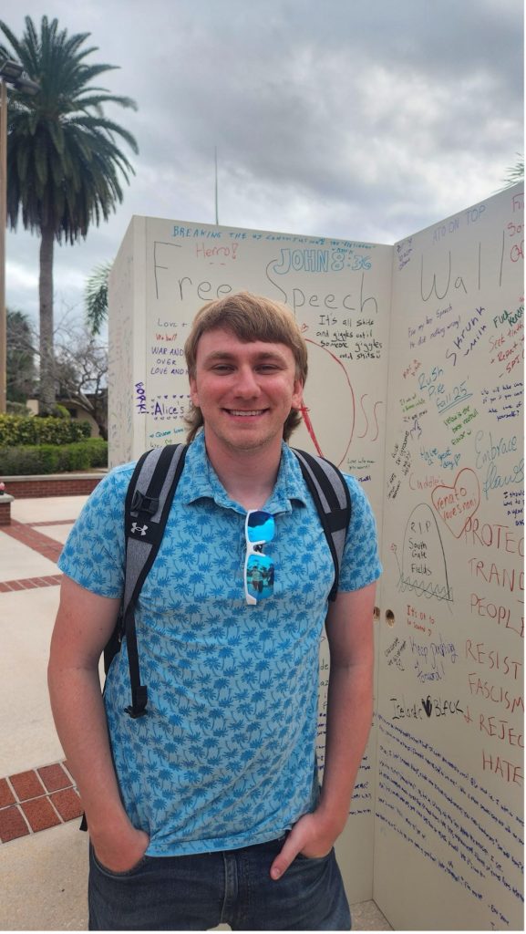 Spencer Tab, an aerospace engineering master’s student, stands in front of the Free Speech Wall during the weeklong Free Speech Week event in February.